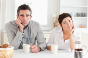 Tired Couple Drinking Coffee In A Kitchen